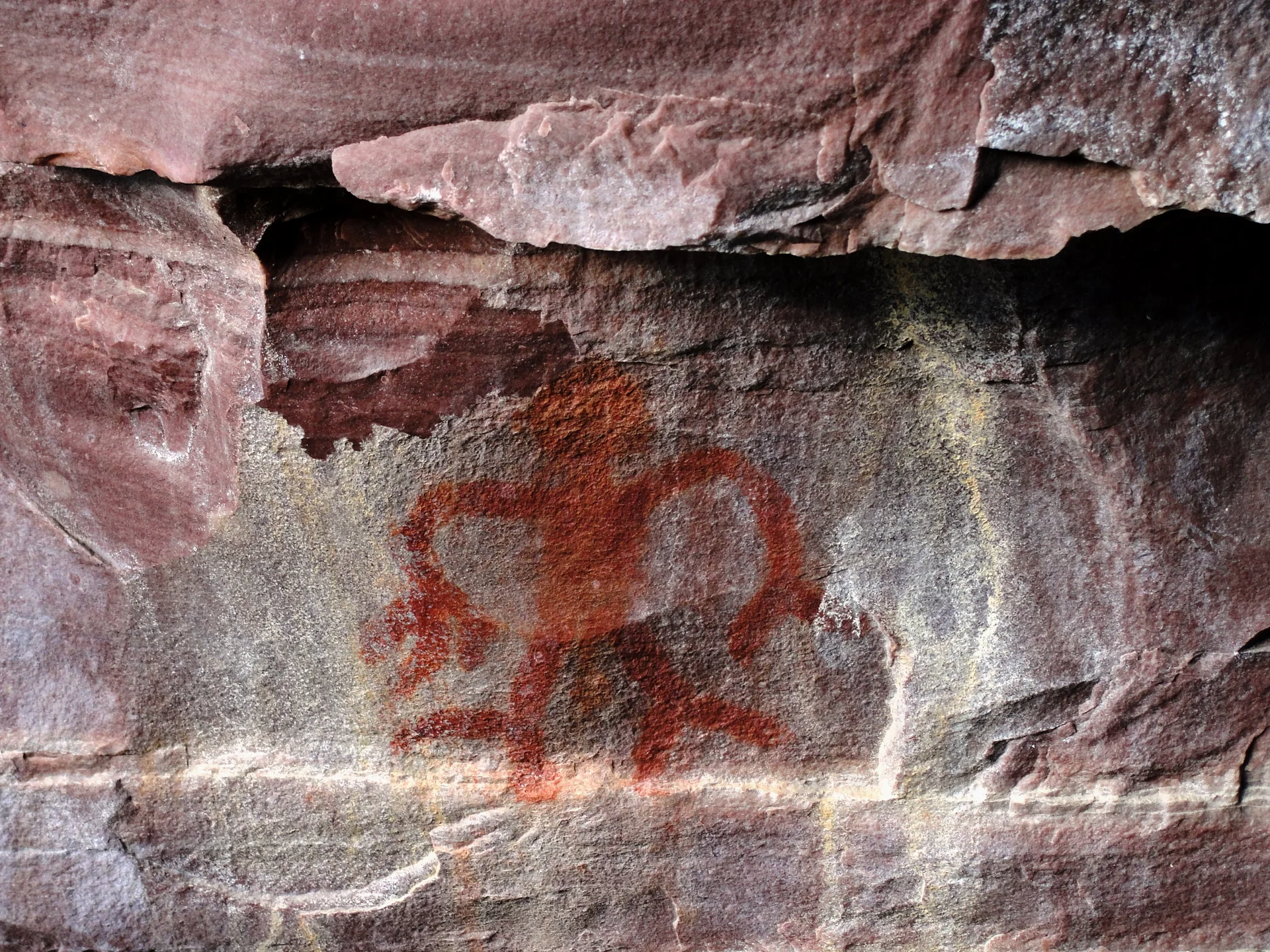 Inscrição rupestre em rocha na Serra das Paridas, na Chapada Diamantina, com motivo humano pintado em tons avermelhados.
