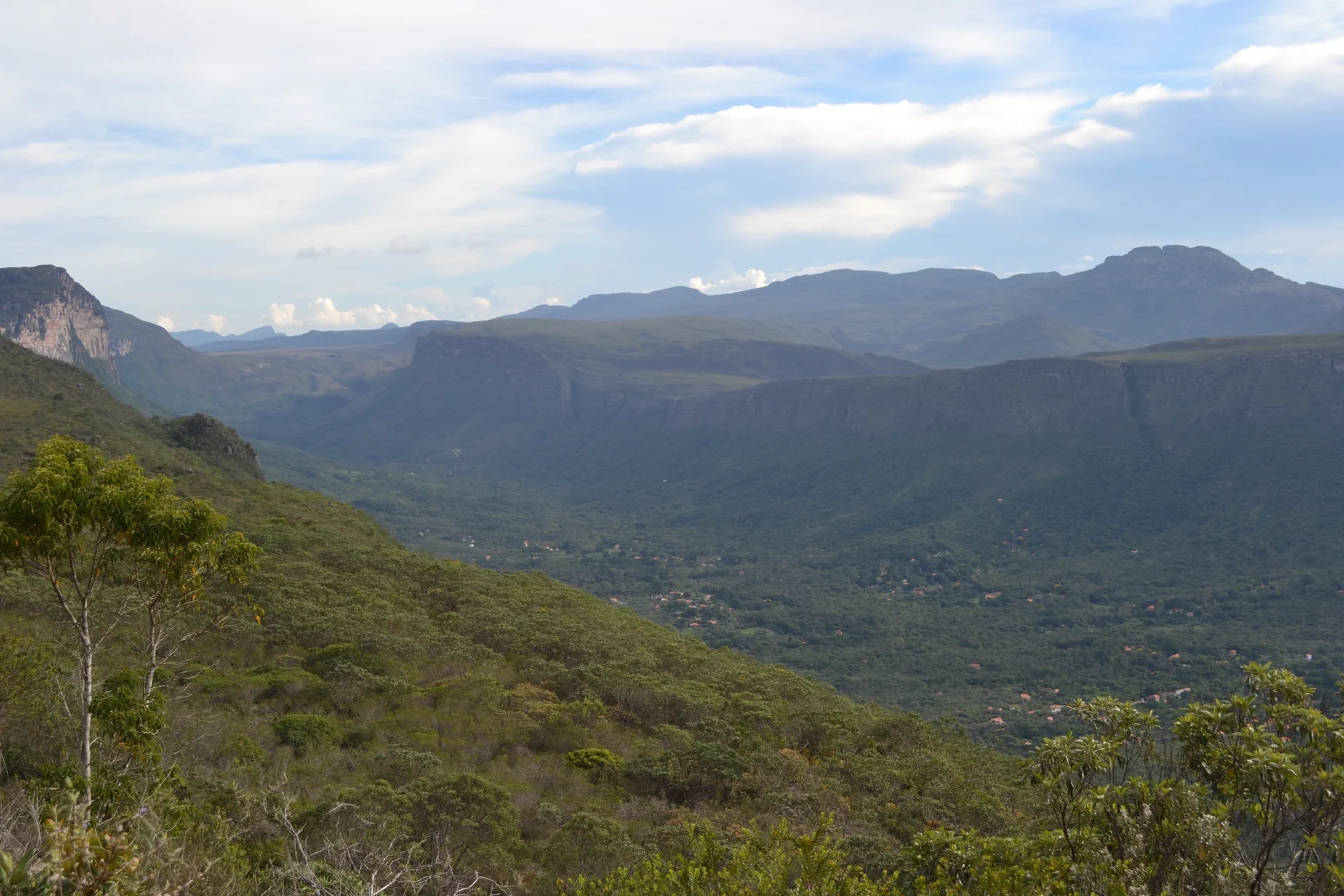 Paisagem de campo rupestre na Chapada Diamantina, com montanhas, afloramentos e vegetação sob luz natural clara.