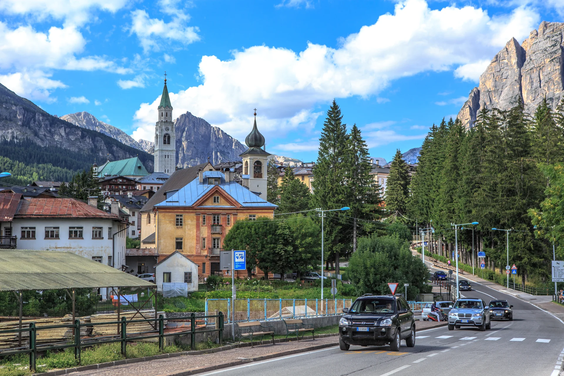 Vista diurna de Cortina d’Ampezzo, no Veneto, com a igreja de Santi Filippo e Giacomo e montanhas das Dolomitas ao fundo.