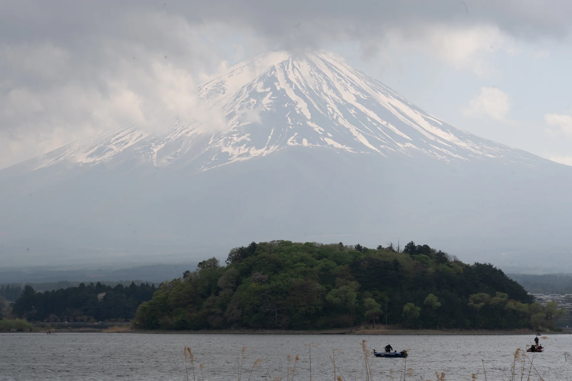 Nuvens naturais cobrem parte do cume do Monte Fuji, visto sobre o Lago Kawaguchi.