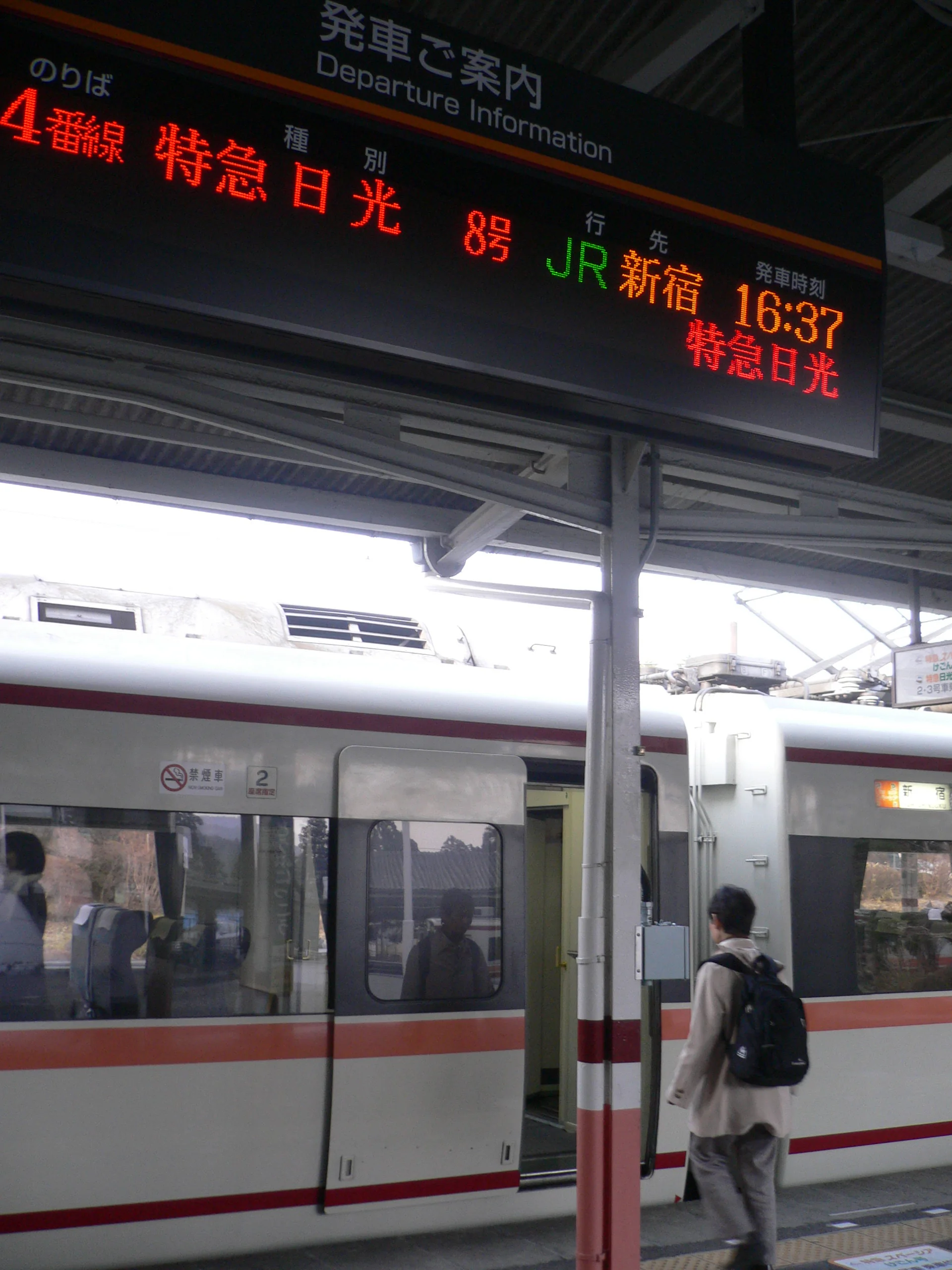 Trem da Tobu Railway parado na plataforma da estação Tobu-Nikko, durante o dia.
