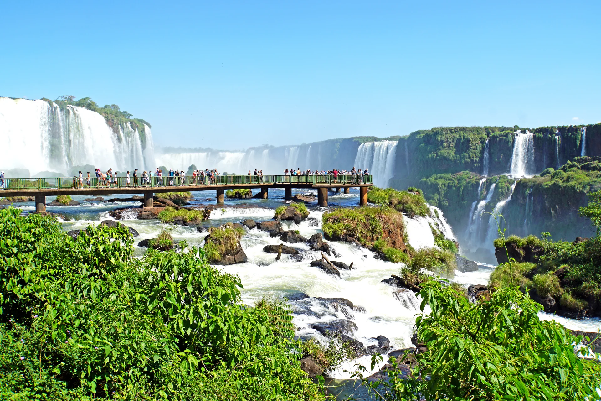 Passarela autorizada junto às Cataratas do Iguaçu, com quedas e vegetação em luz natural.
