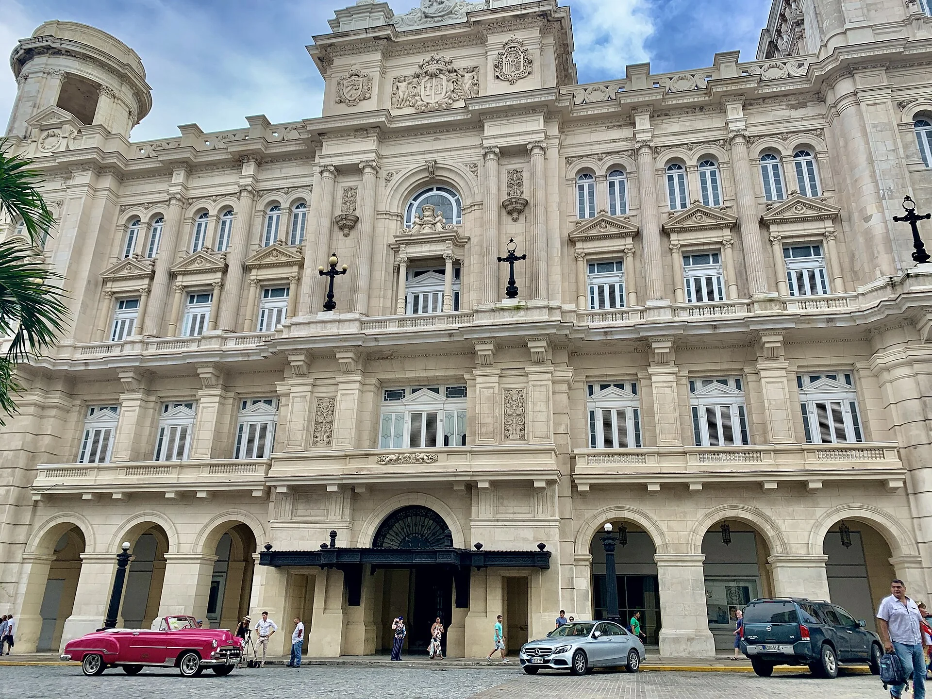 Fachada clara e ornamentada do Museo Nacional de Bellas Artes de La Habana, vista da rua sob luz diurna.