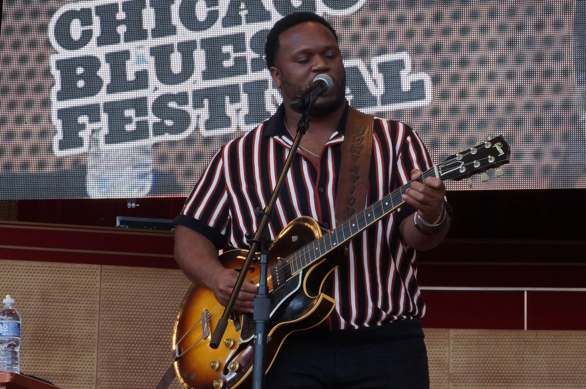 Músico de jazz em apresentação ao vivo em Chicago, com saxofone e iluminação de palco, em imagem editorial licenciada.