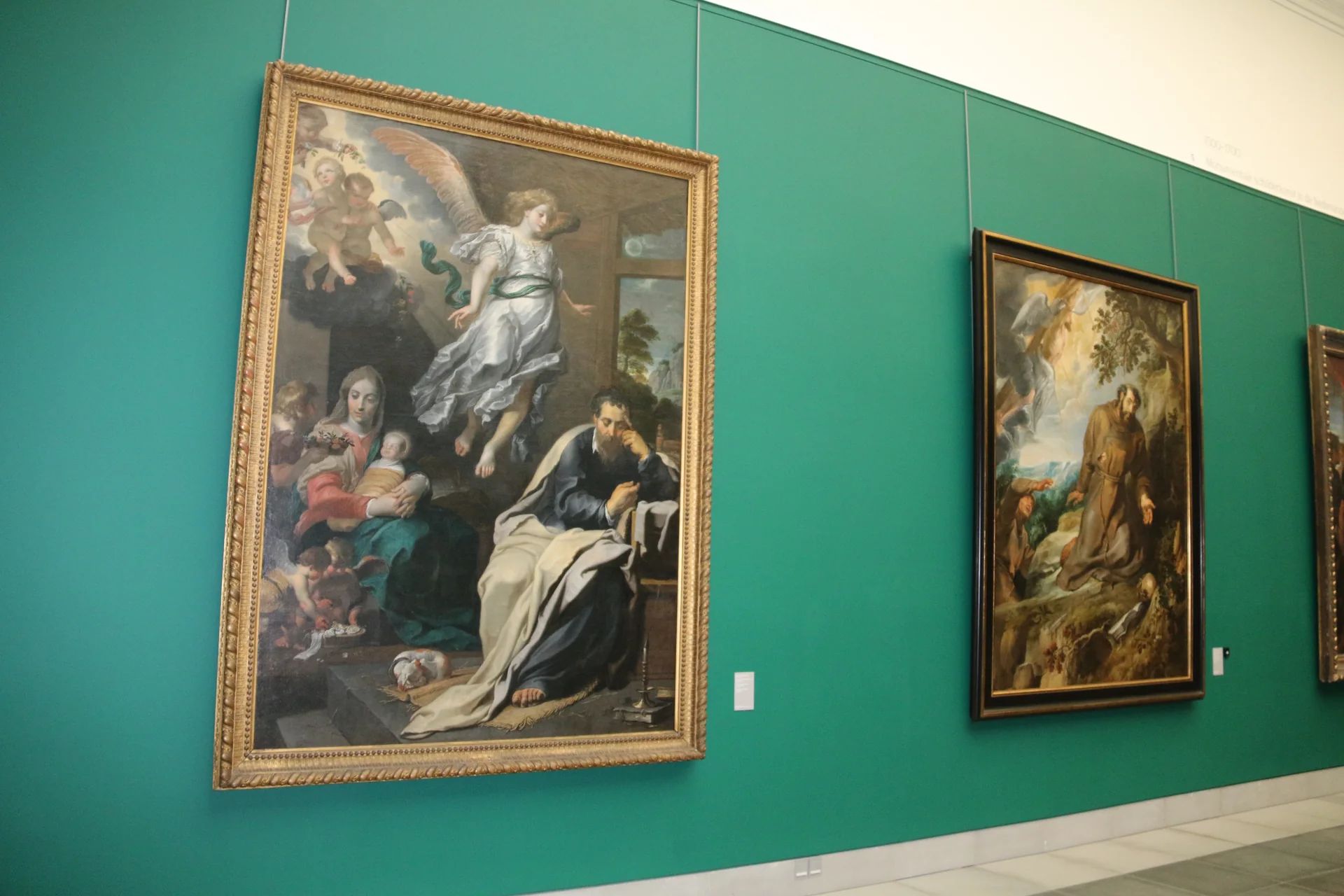 Sala do MSK Gent com pinturas emolduradas em paredes verde-esmeralda, registrada em luz ambiente.