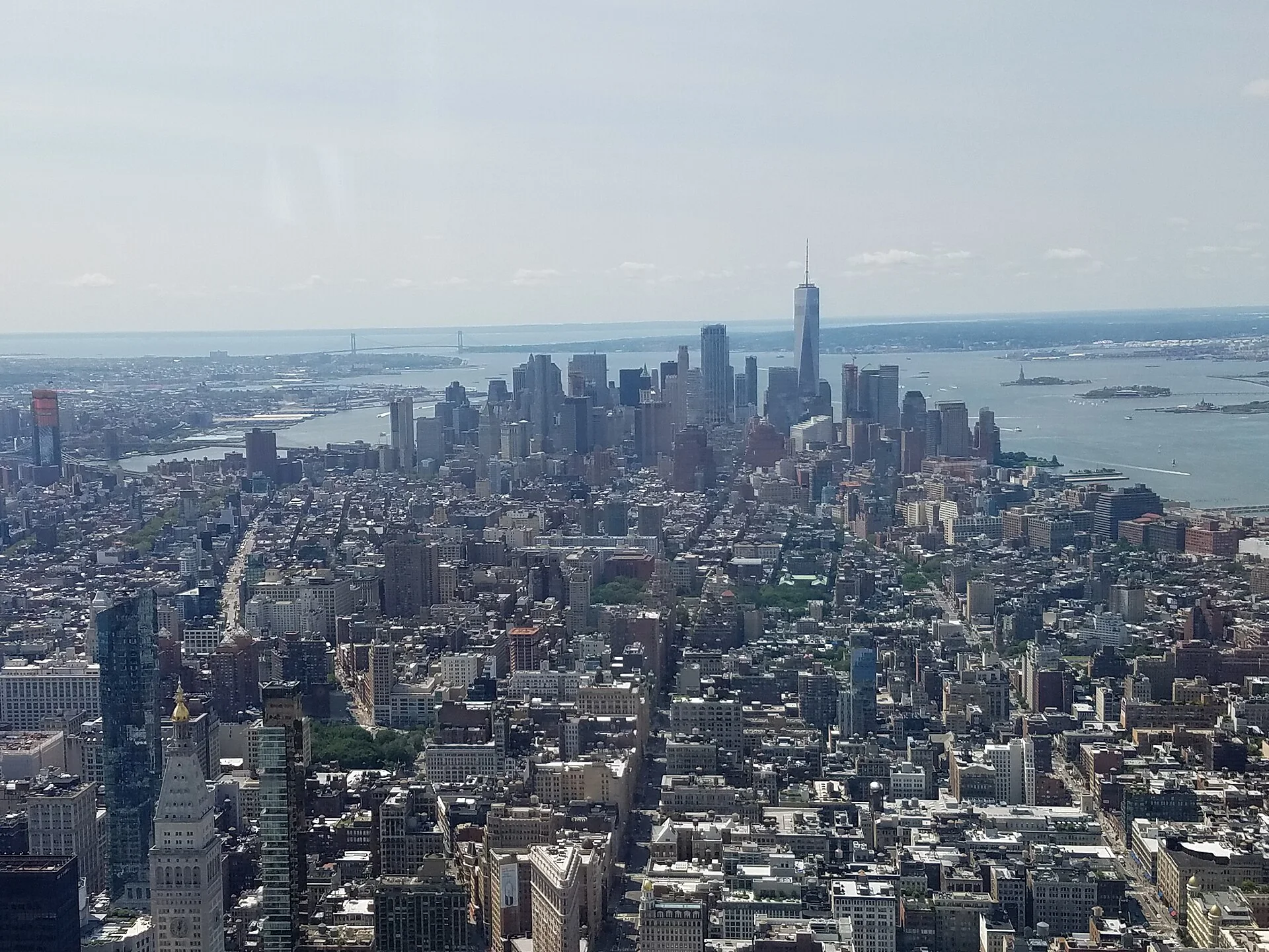 Vista diurna de Lower Manhattan a partir do Empire State Building, com One World Trade Center, os rios Hudson e East River e o sul da ilha.