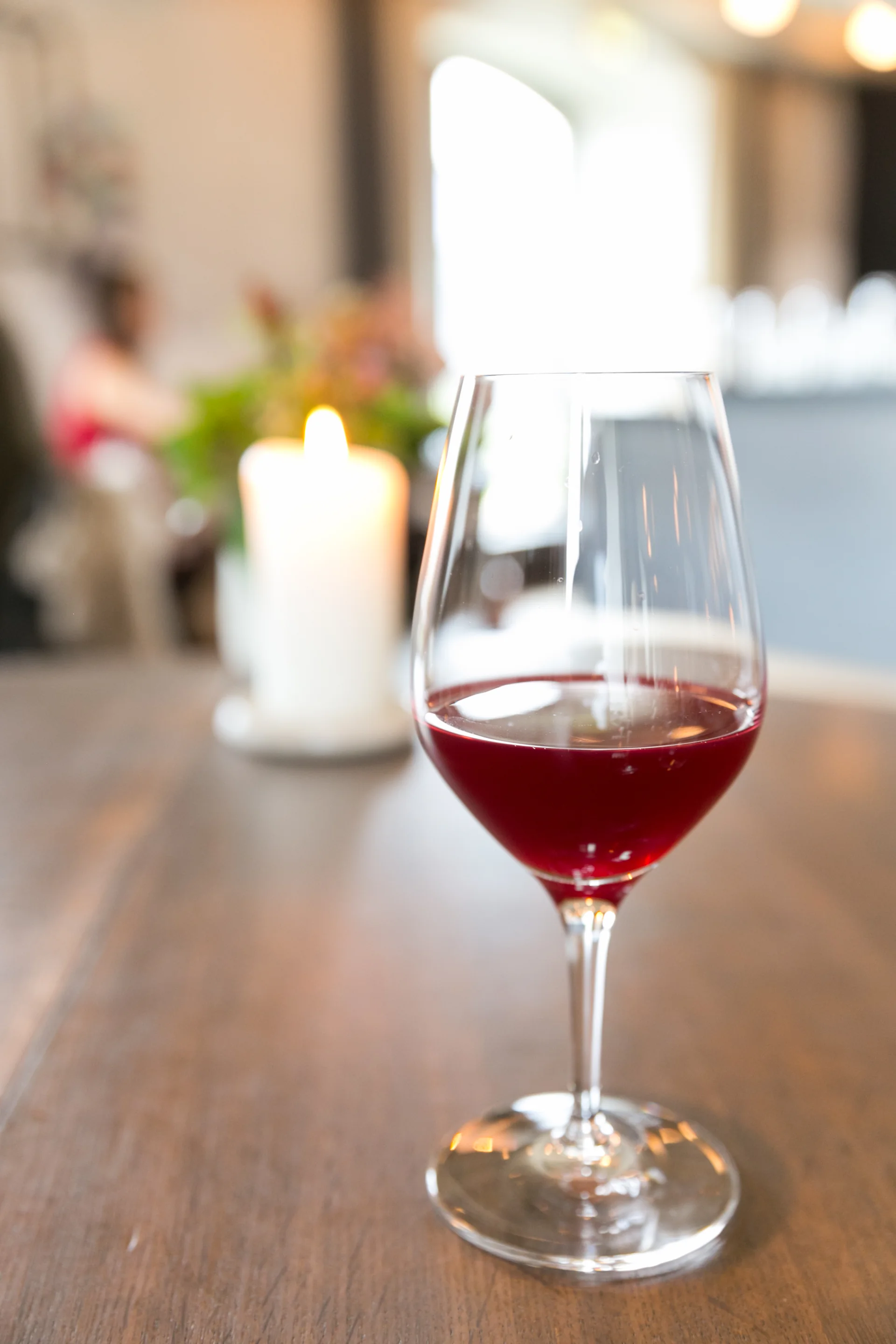 Copo com suco de uva servido à mesa, fotografado em ambiente de restaurante.