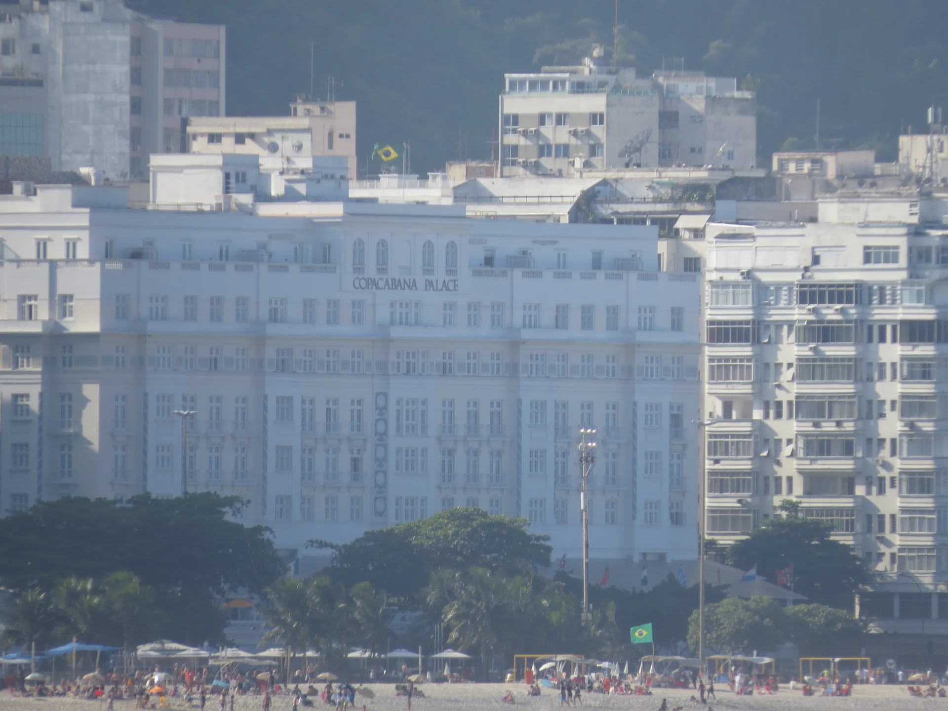 Fachada do Copacabana Palace vista da direção do Forte de Copacabana, com a praia ao primeiro plano.