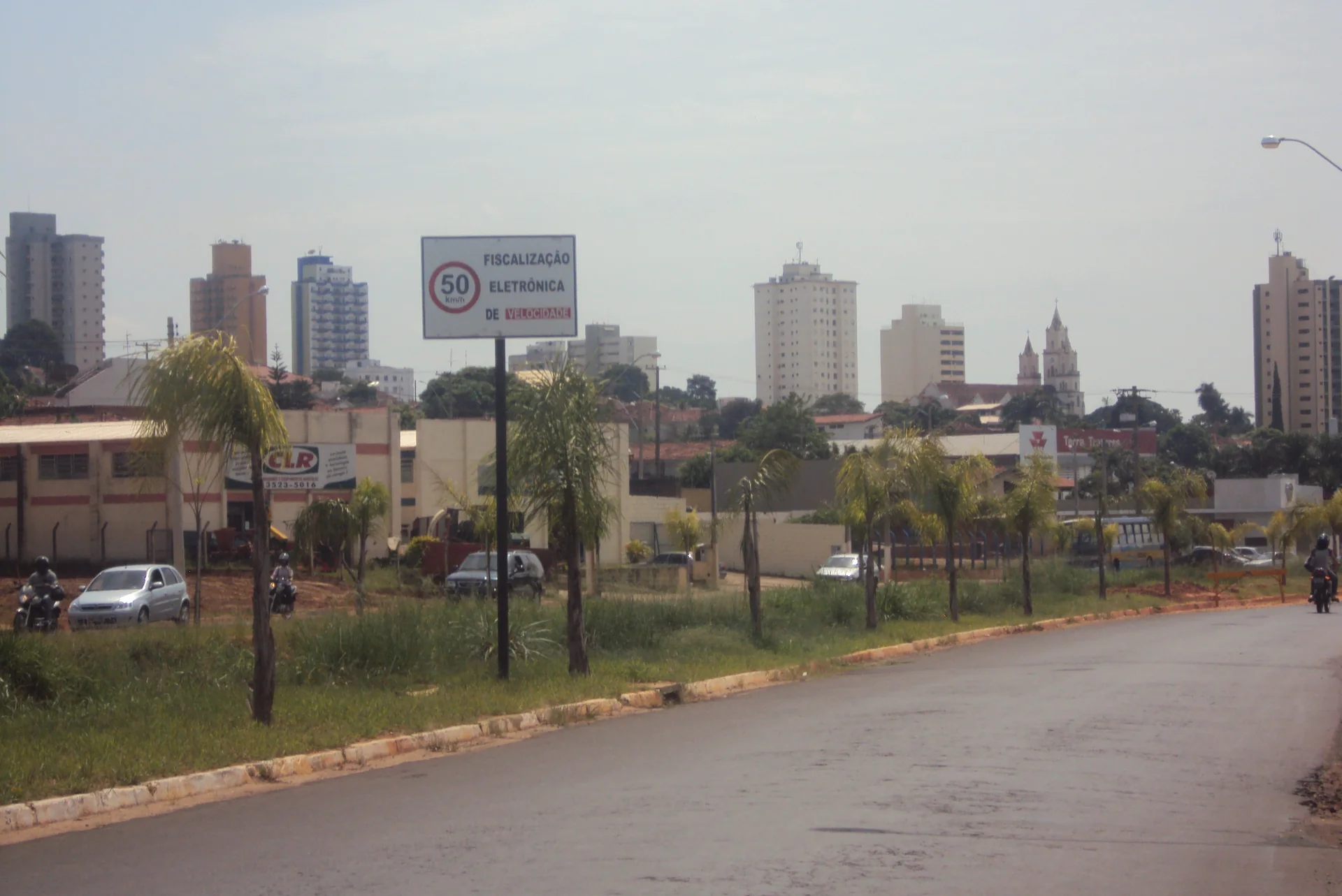 Avenida Tiradentes em Lins, com palmeiras e edifícios sob luz diurna; é contexto do destino e não representa o parceiro, a propriedade ou seus serviços.