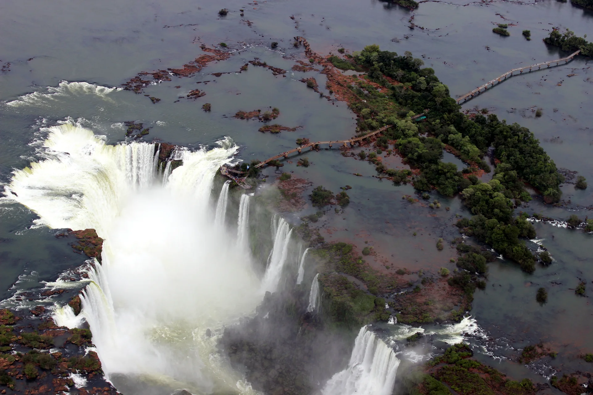 Vista aérea das Cataratas do Iguaçu, com a passarela sobre o rio e a Garganta do Diabo ao fundo.