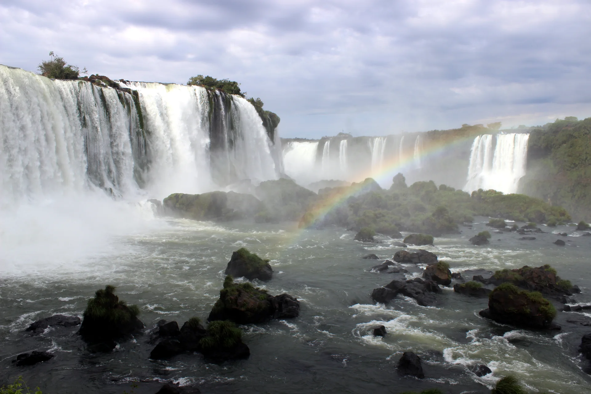 Quedas das Cataratas do Iguaçu vistas do mirante da Garganta do Diabo, com arco-íris sobre o rio.