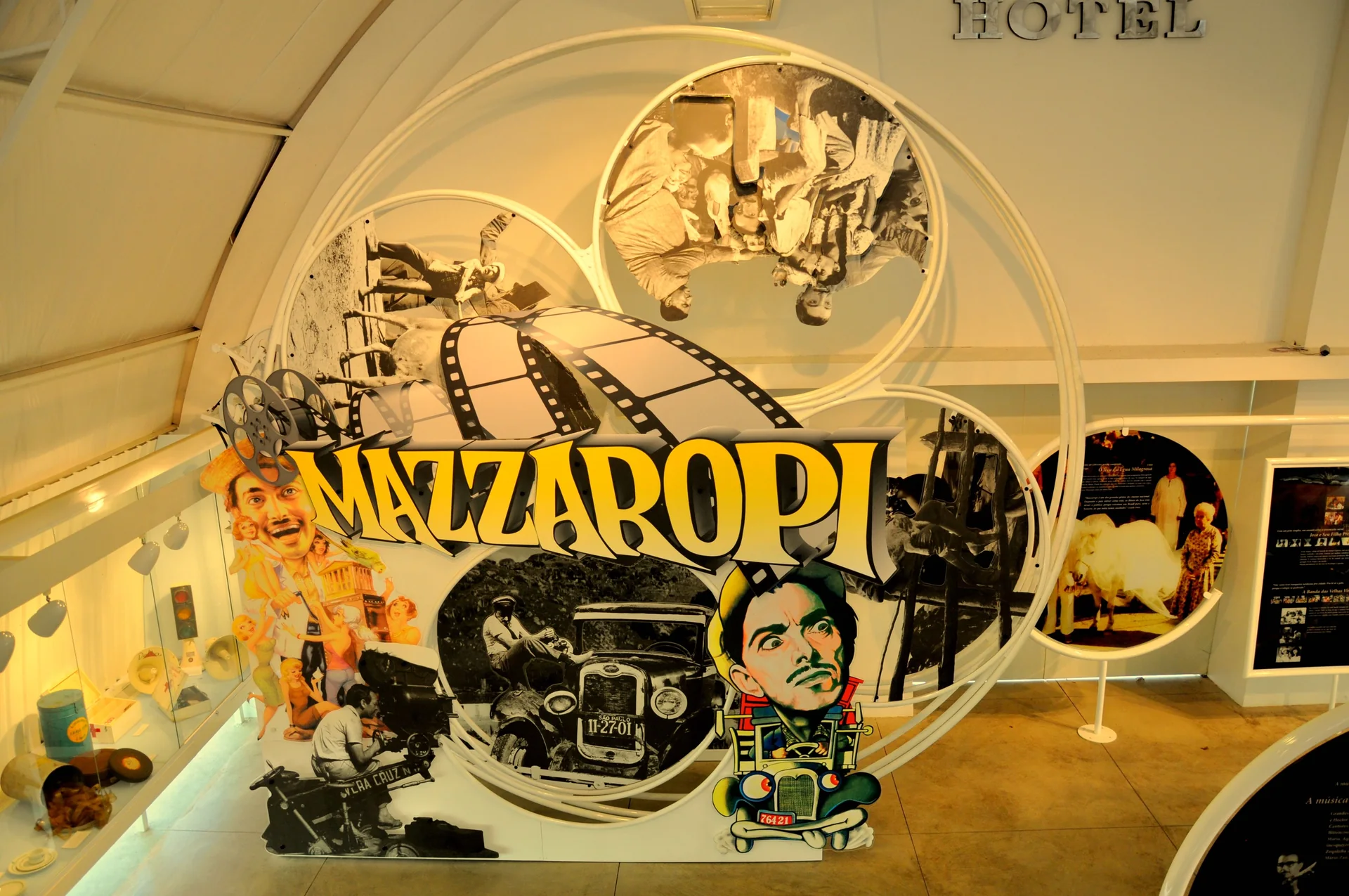 Contexto do destino: exposição interna do Museu Mazzaropi em Taubaté, com painel circular e referências ao cinema brasileiro; esta imagem não representa o Hotel Fazenda Mazzaropi.