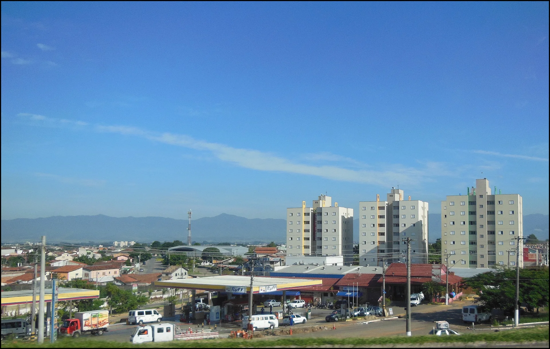 Contexto do destino: vista diurna de Taubaté com edifícios, céu azul e Serra da Mantiqueira ao fundo; esta imagem não representa o Hotel Fazenda Mazzaropi.