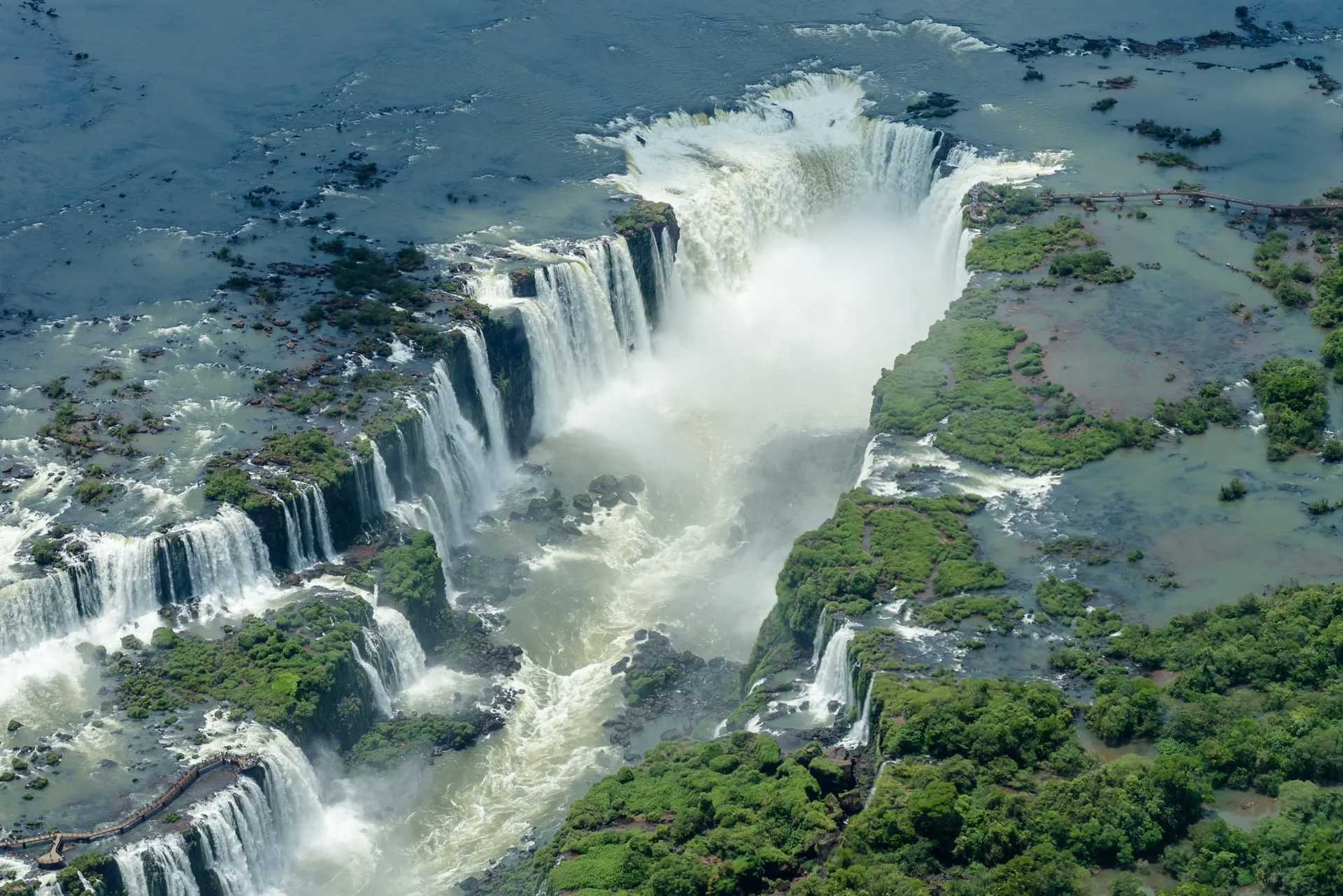 Imagem de contexto de vista aérea clara das Cataratas do Iguaçu e da vegetação ao redor. Esta imagem é contexto e não representa o parceiro, a propriedade ou o serviço da Orinter Tour & Travel.