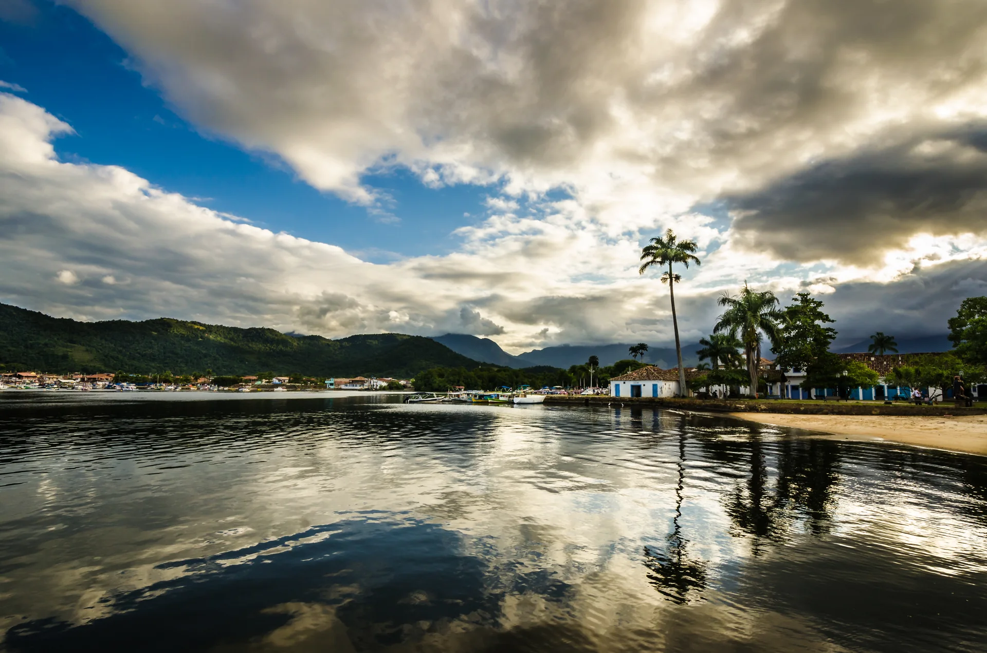 Imagem contextual de Paraty vista junto ao mar, com casario, barcos e montanhas; não retrata a Pousada Literária.