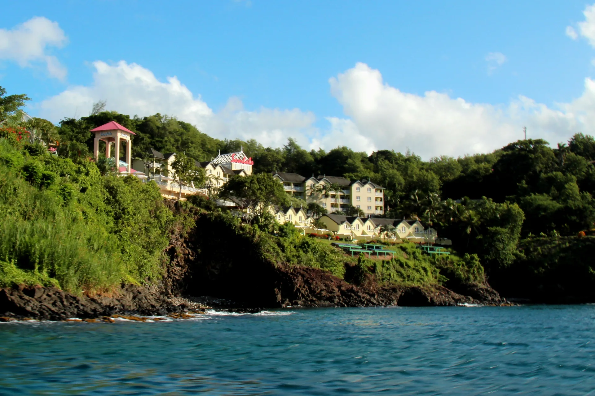 Vista diurna do Sandals Regency La Toc em encosta verde junto ao mar, em Saint Lucia.